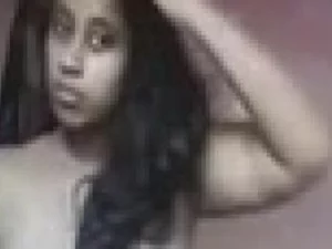 Eine junge tamilische Frau mit großen Brüsten zieht sich verführerisch aus und posiert.